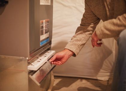 A person changing a furnace air filter