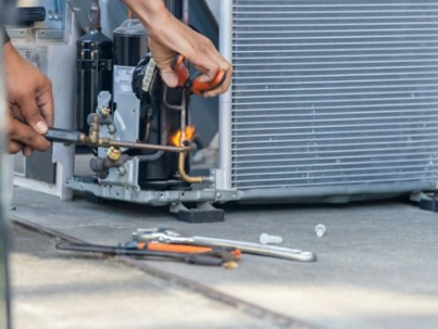 Technician brazing air conditioner pipes