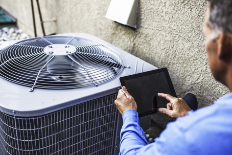 Technician inspecting outdoor AC unit