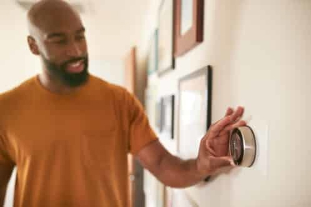 Man adjusting a smart thermostat