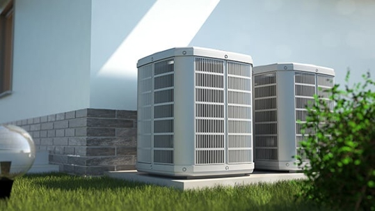 Two outdoor central air conditioning units