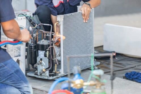 Technicians repairing an HVAC unit