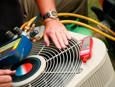 HVAC technician servicing outdoor AC unit