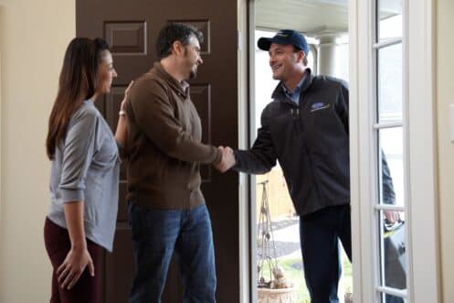 A technician shakes hands with the homeowner