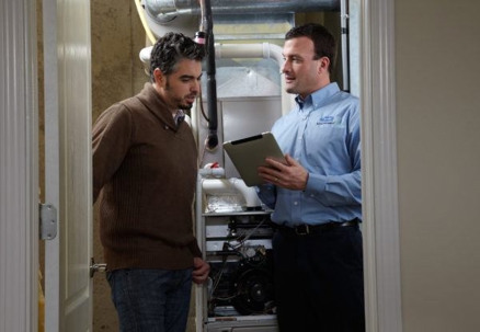 Technician showing furnace to homeowner