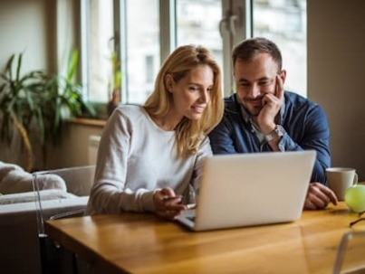 A couple looking at a laptop together.